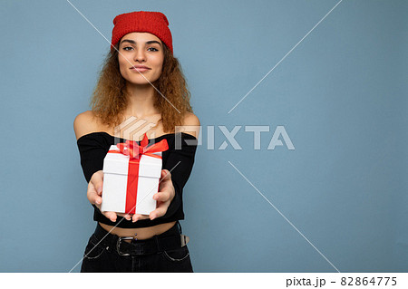 Shot of beautiful positive smiling young dark blonde curly woman isolated over blue background wall Shot of beautiful positive smiling young dark blonde curly woman isolated over blue background wall 82864775