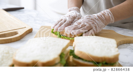 ビニール手袋で調理、サンドウィッチ作り、調理する主婦の手元 82866438