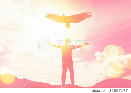 Man raise hand up on top of mountain and sunset sky with eagle birds fly abstract background. 82867177