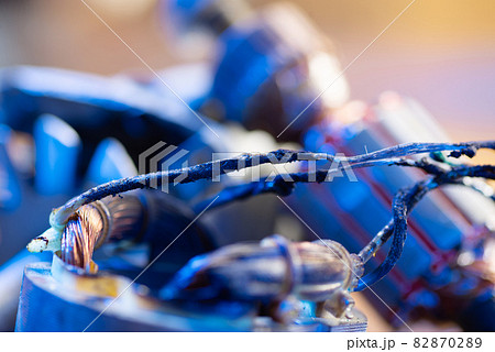 Burnt wires on the parts of an electrical appliance, drills on a wooden table in a repair shop. Power tool repair Burnt wires on the parts of an electrical appliance, drills on a wooden table in a repair shop. Power tool repair 82870289