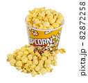 Tasty popcorn with caramel falling into cups on white background 82872258