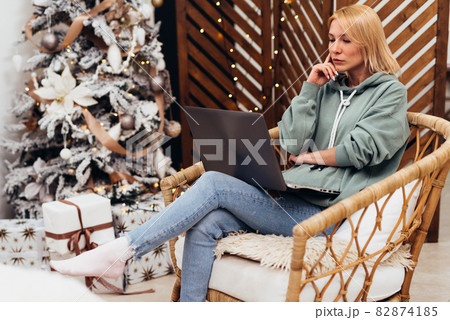 Young woman using laptop computer while sitting on chair at home. Young woman using laptop computer while sitting on chair at home. 82874185