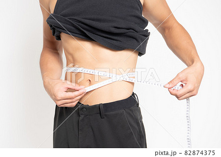 白背景の前に立っている男性のお腹 白背景の前に立っている男性のお腹 82874375