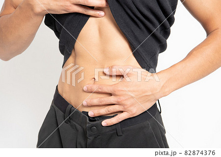 白背景の前に立っている男性のお腹 82874376