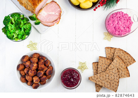 Christmas table with baked ham, beet salad, whole grane crackers, meatballs with lingonberry jam 82874643