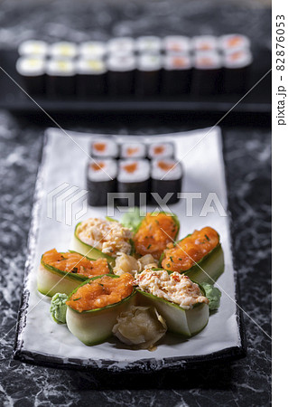 set of sushi rolls with seafood on a black stone background set of sushi rolls with seafood on a black stone background 82876053
