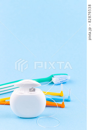 Dental floss, toothbrush and interdental brush angles on blue background, vertical, copy space Dental floss, toothbrush and interdental brush angles on blue background, vertical, copy space 82876538