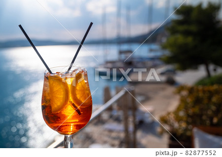 Orange drink or cocktail standing at the little table at the restaurant or cafe with sea background 82877552