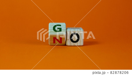 No or go symbol. Turned a cube, changed the word 'no' to 'go'. Beautiful orange background. Copy space. Business, motivation and no or go concept. No or go symbol. Turned a cube, changed the word 'no' to 'go'. Beautiful orange background. Copy space. Business, motivation and no or go concept. 82878206