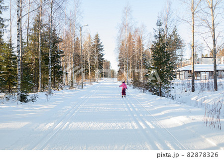 Small child in the ski track at winter forest in Finland. 82878326