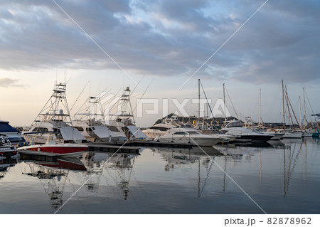 Many motorboats and sailboats Docked at a Marina on dramatic sunrise background 82878962