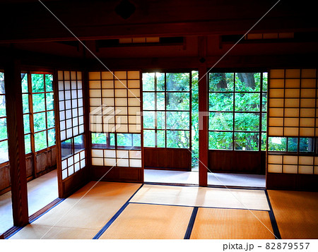 縁側に障子と畳のある純日本的な和室の窓の外に緑の日本庭園が見える風景 の写真素材