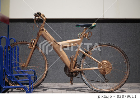 The bike on the street is painted gold. The bike on the street is painted gold. 82879611