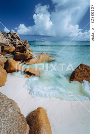 Beautifully shaped granite boulders and blue lagoon at Grand Anse beach, La Digue island, Seychelles 82880107