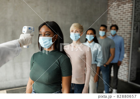 International group of people in face masks checking body temperature 82880657