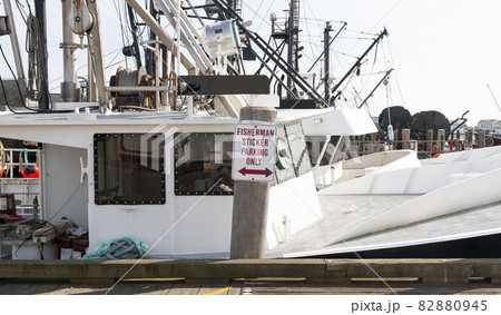 Sign reads fisherman parking only at a commercial dock with fishing vessals Sign reads fisherman parking only at a commercial dock with fishing vessals 82880945