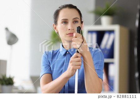 Blind woman with absent gaze looks into the distance and holds stick Blind woman with absent gaze looks into the distance and holds stick 82881111