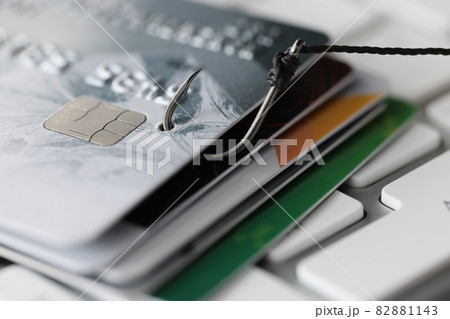 Plastic bank cards and fishing hook on white computer keyboard 82881143