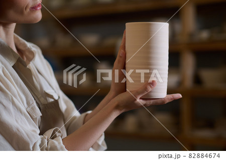 Hands of a potter with a newly made pot Hands of a potter with a newly made pot 82884674