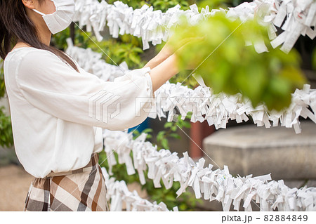 おみくじを結ぶ女性　神社と女性　おみくじを結ぶ人 82884849