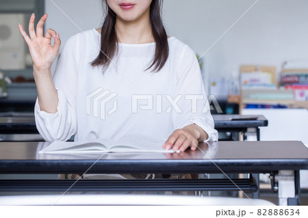 デスクで本を開いてサインを送る女性 サインを送る人 デスクで本を開いてサインを送る女性 サインを送る人 82888634