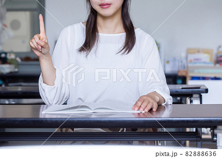 デスクで本を開いてサインを送る女性　サインを送る人 82888636