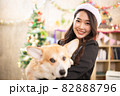 young asian attractive female woman wearing red hat and  playing with her dog  at office weekend holiday activity christmas festival concept 82888796