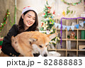 young asian attractive female woman wearing red hat and  playing with her dog  at office weekend holiday activity christmas festival concept 82888883