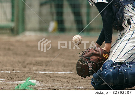 野球の試合中にピッチャーの投げた球を受けようとして体で球を止めるキャッチャー 82892207
