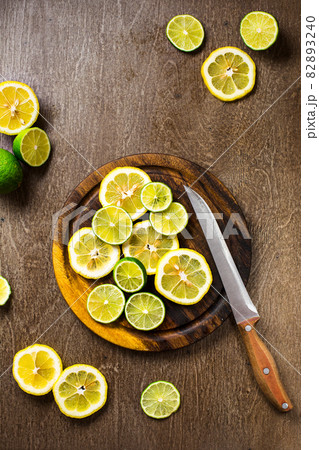 sliced on lemon, lime slate and wooden counter top background 82893240