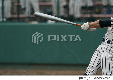 野球の試合中にピッチャーの投げた球を打ちバットを振り抜いた左バッター 82895292