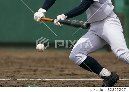 野球の試合中にピッチャーの投げた球をバントする左バッター 82895297