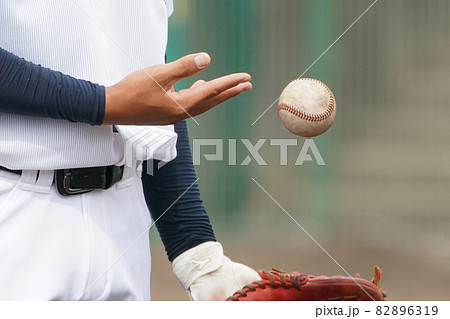 野球の試合前のシートノック中にボールをグローブに投げ入れる選手の手元の写真素材 6319