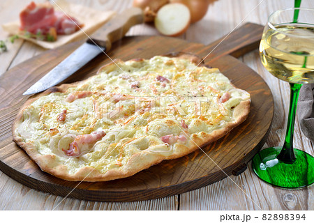 Tarte flambee from Alsace with onions, smoked bacon and munster cheese 82898394