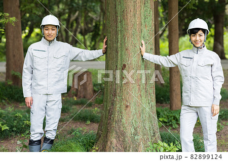 森に立つ作業着を着た若い男女 森に立つ作業着を着た若い男女 82899124