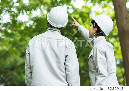 森に立つ作業着を着た若い男女 82899134