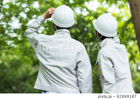 森に立つ作業着を着た若い男女 森に立つ作業着を着た若い男女 82899187