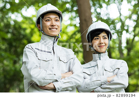 森に立つ作業着を着た若い男女 82899194