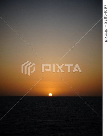 【マダガスカル】夕日でオレンジ色に染まったビーチと水平線に沈む太陽（サラリー） 82904097