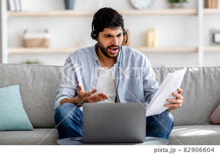 Young arab man having video conference, working with financial documents, discussing annual reports, having problems Young arab man having video conference, working with financial documents, discussing annual reports, having problems 82906604