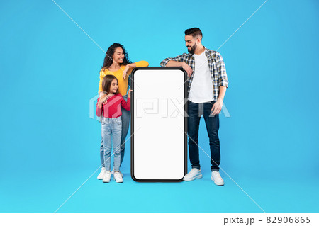 Arabic Family Leaning At Smartphone With Empty Screen, Blue Background Arabic Family Leaning At Smartphone With Empty Screen, Blue Background 82906865