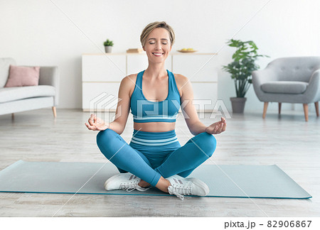 Lady meditating in lotus pose at home Lady meditating in lotus pose at home 82906867