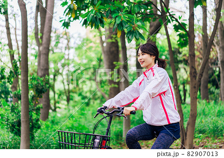 自然の中でサイクリングを楽しむ若い女性 82907013