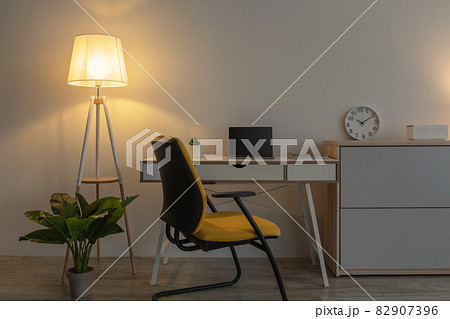 Modern armchair, table with laptop with empty screen, furniture with plant, clock Modern armchair, table with laptop with empty screen, furniture with plant, clock 82907396