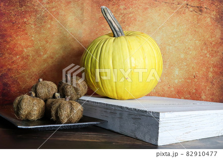 A yellow and twine pumkins against a orange background A yellow and twine pumkins against a orange background 82910477