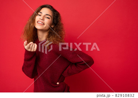 Portrait of young positive happy attractive brunette curly woman with sincere emotions wearing 82910832