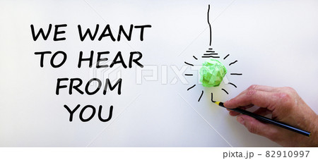 Support symbol. Businessman writing 'we want to hear from you', isolated on beautiful white background. Light bulb icon. Business and support concept. Copy space. 82910997