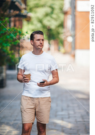 Young man drinking coffee in the city outdoors 82911092