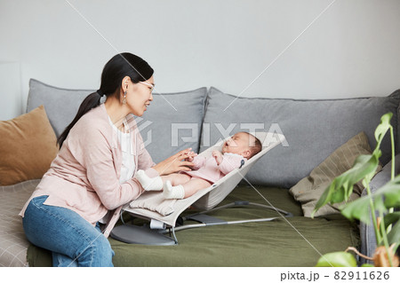 Young mother talking to her baby Young mother talking to her baby 82911626