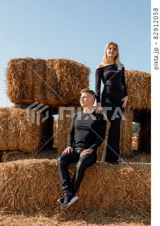Happy family sitting on hay bales. outdoor market. Autumn time. 82912058